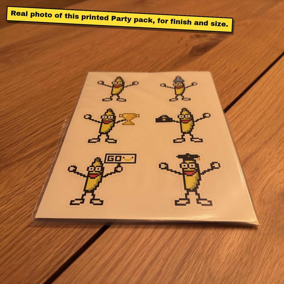 Printed A5 sticker sheet of pixel bananas on a wooden table.