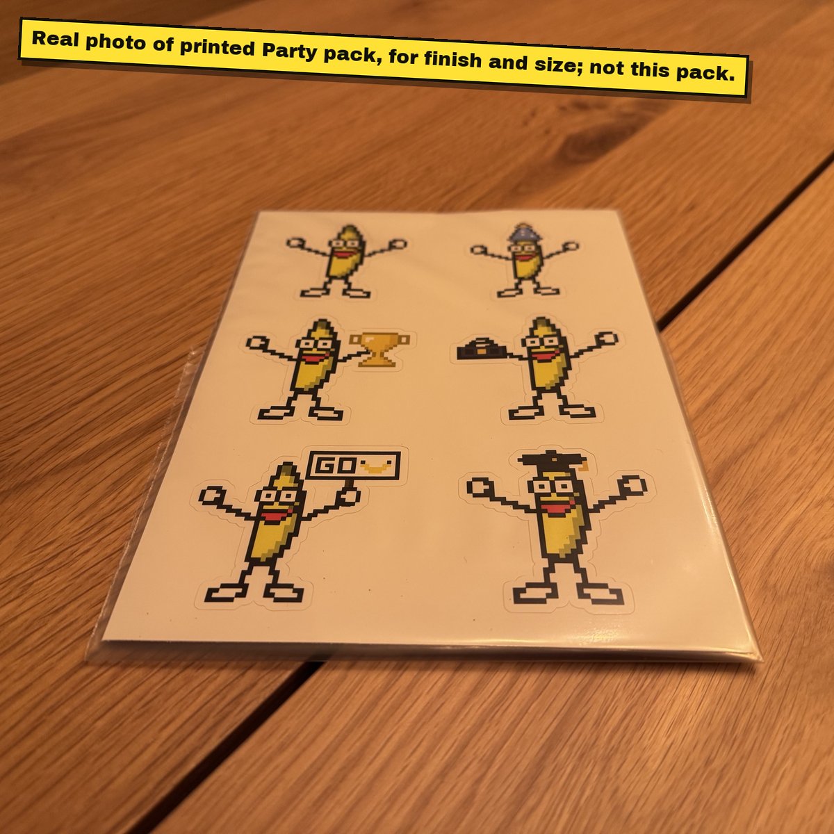 Printed A5 sticker sheet of pixel bananas on a wooden table.