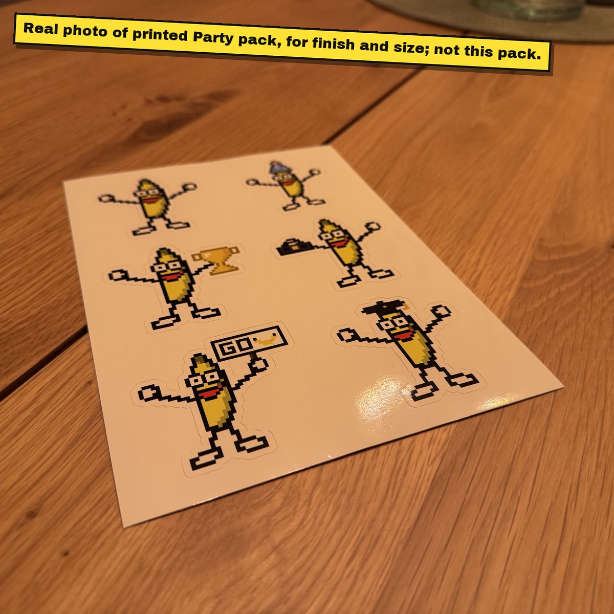 Printed A5 sticker sheet of pixel bananas on a wooden table.
